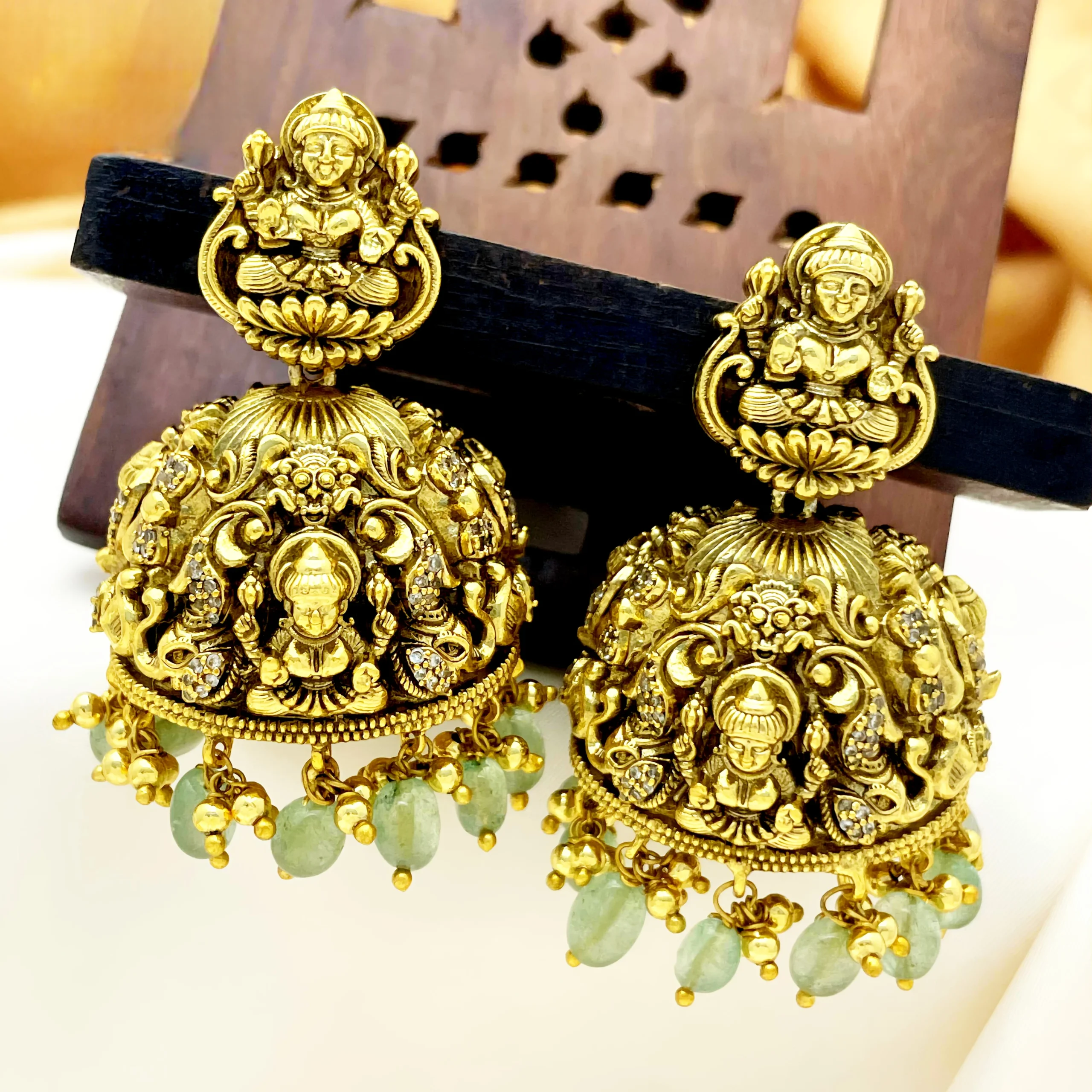 Traditional temple jhumka earrings with Lakshmi design and green bead drops